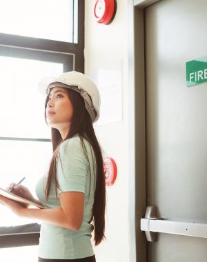 Femme préparant un plan de sécurité près d'une sortie de secours